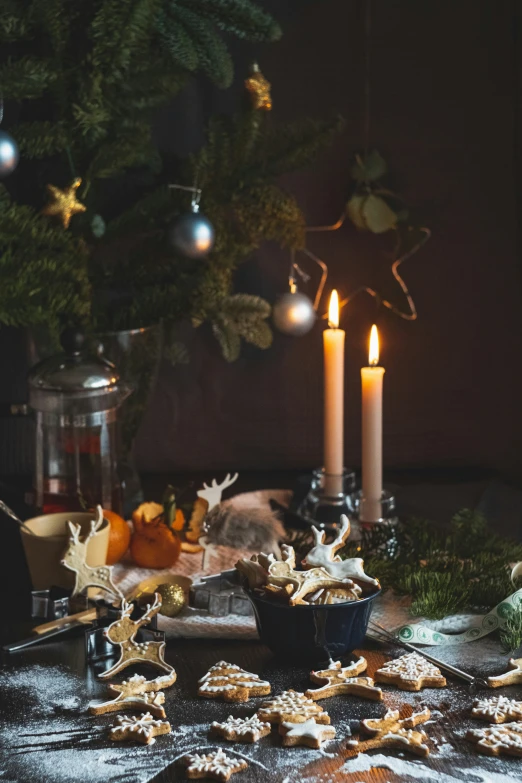 a table topped with christmas cookies and candles