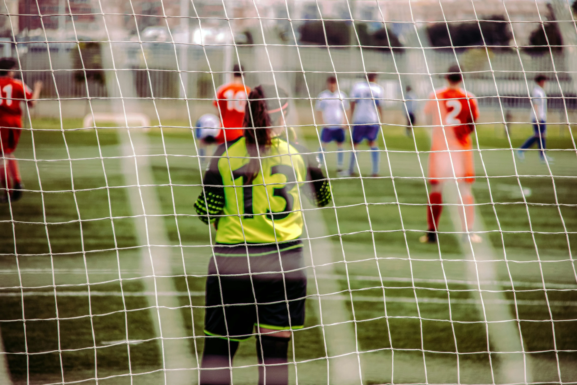 soccer players playing a game of soccer in a net