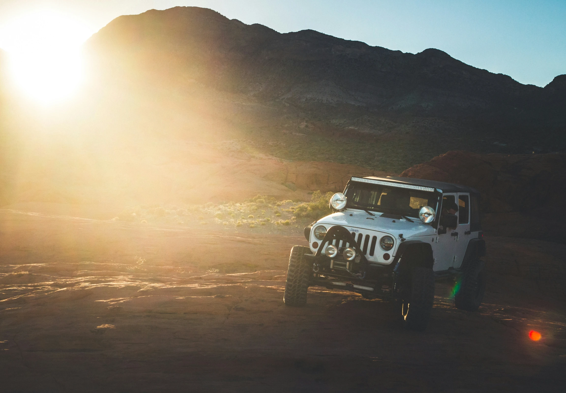 a jeep on a dirt road in the sun