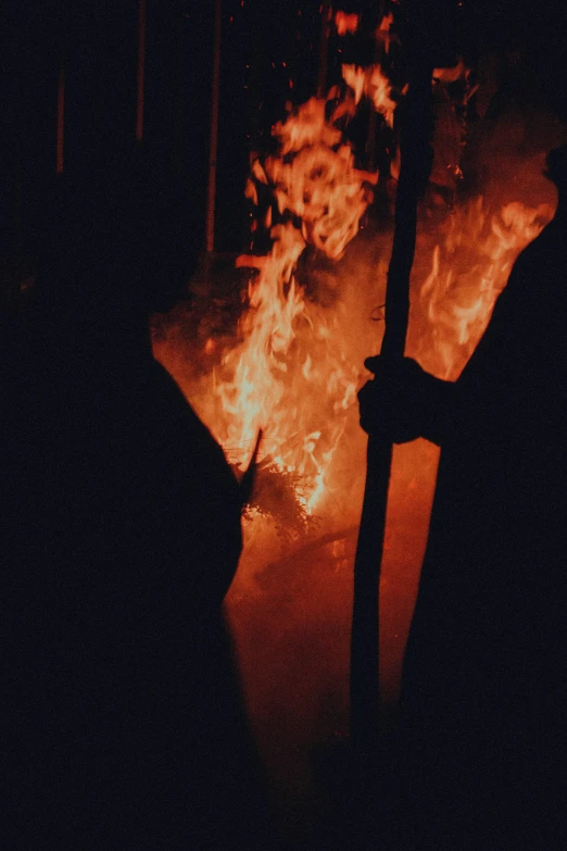 a man wearing a hat on a cell phone near a fire