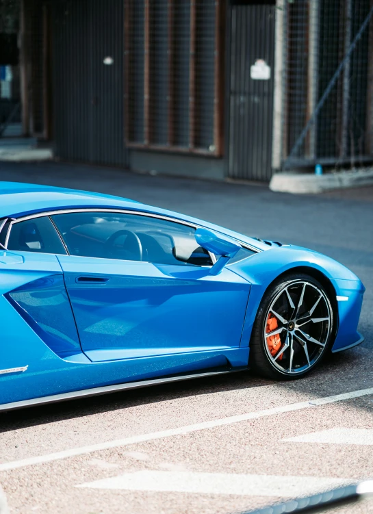 a blue sports car parked on a side walk