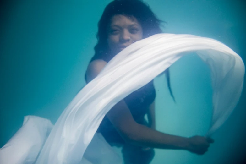 the woman in the swim suit is covering herself with a large white piece of paper