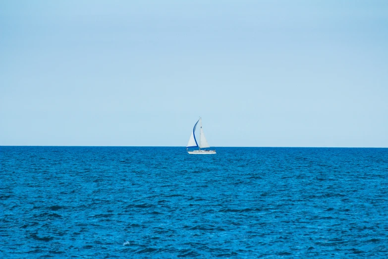 a sailboat with two masts is anchored in a bay