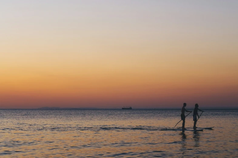 two people are on boards in the ocean