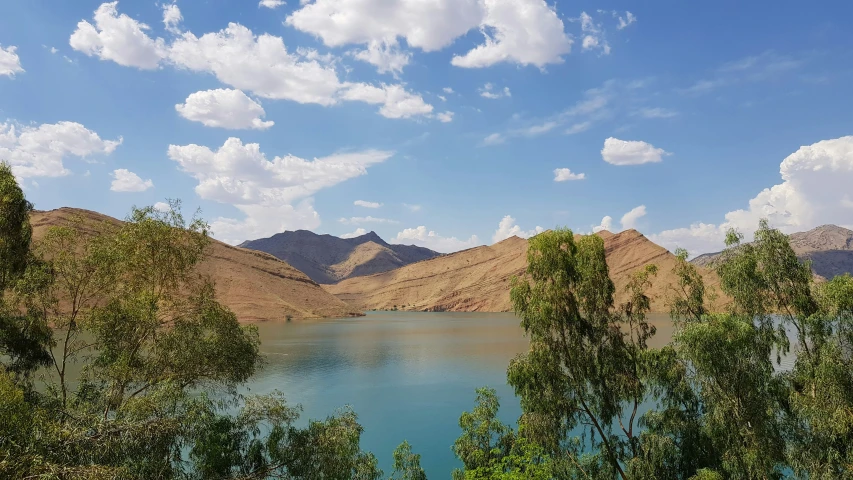 a landscape po looking over water, hills and clouds