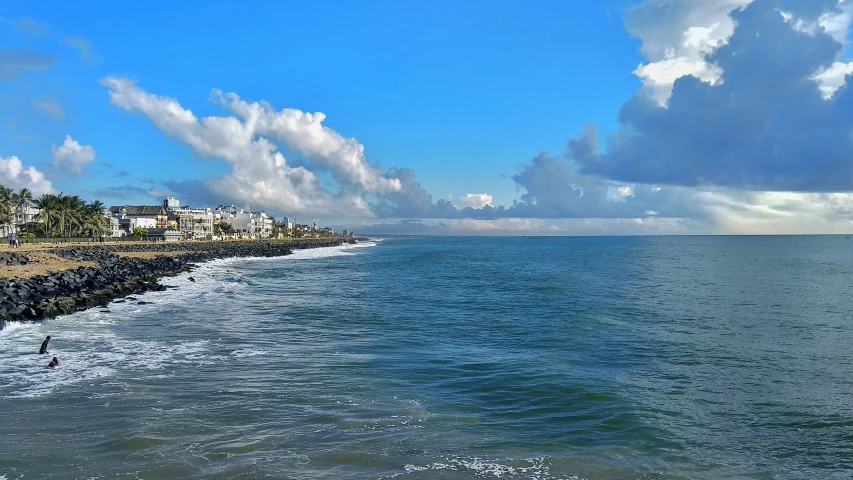 a long sandy shore with a view to a village on the horizon