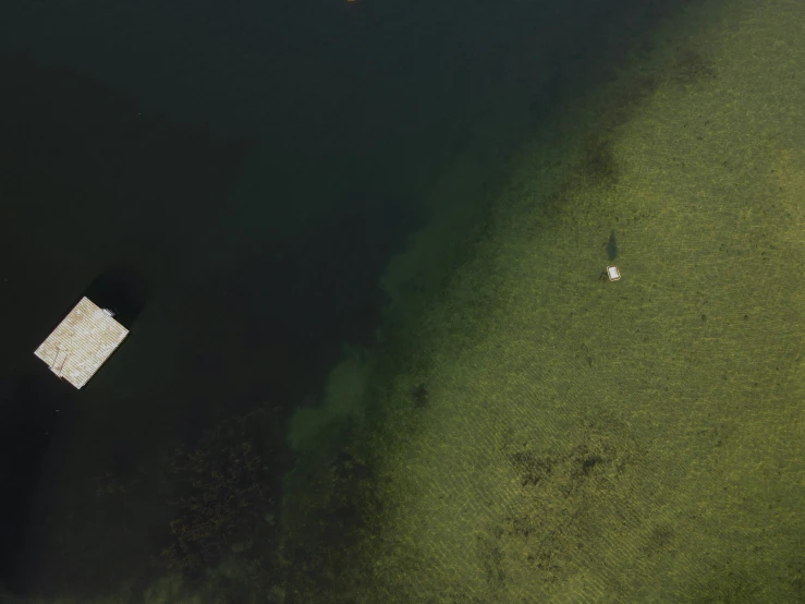 an aerial view of a grassy field next to the ocean