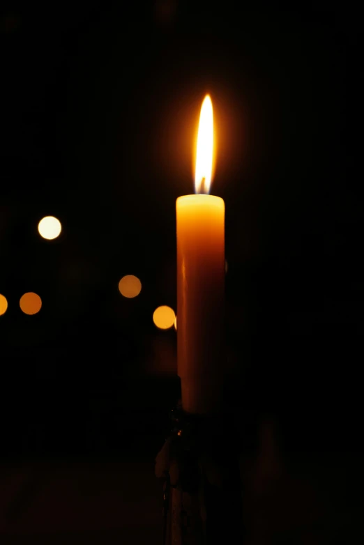 an candle burning brightly in the dark
