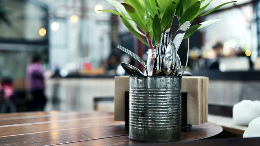 silverware sitting in a metal tin sitting on a table