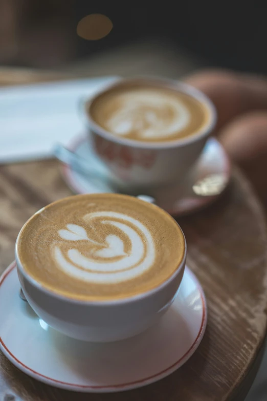 two cups of latte art on top of a table