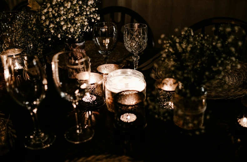 a table with many candles, dishes and glasses