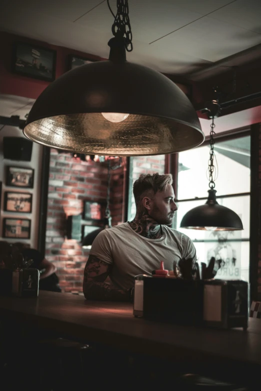 a man sits at a bar looking out the window