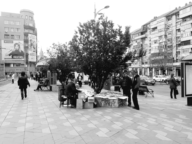 people are standing in the street by tables that have boxes of food