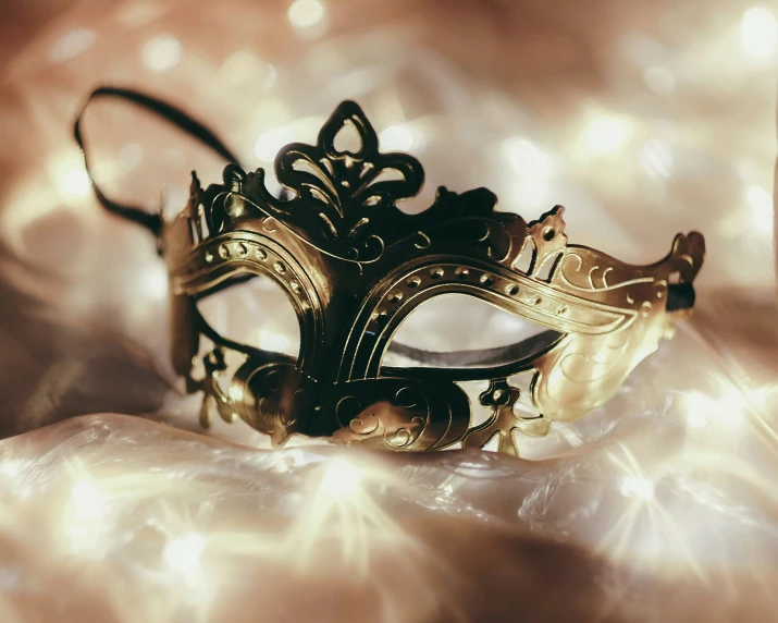 an ornate gold and black masquerade on an ivory background