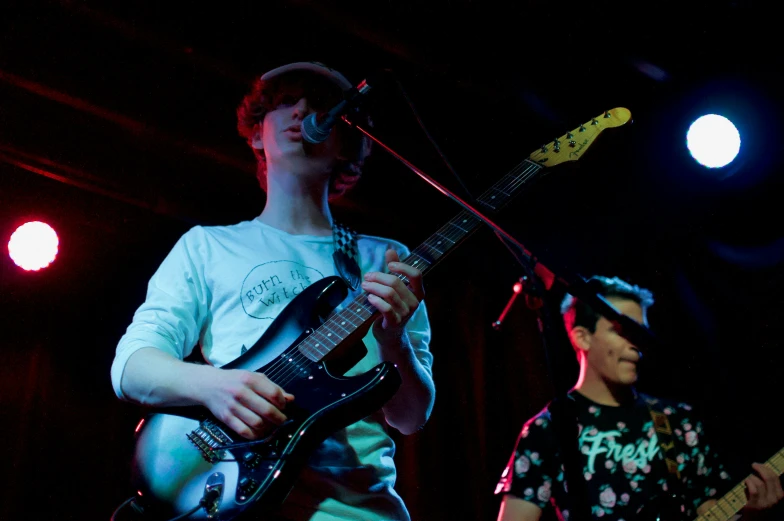 a guy playing a guitar while another plays on a keyboard