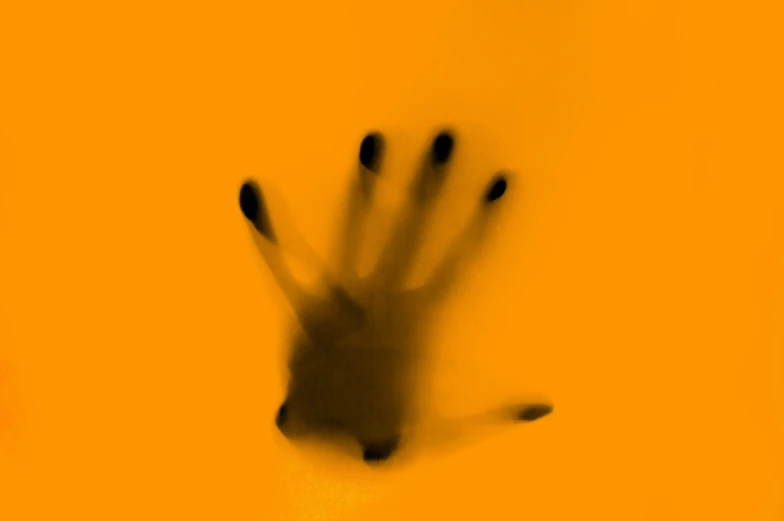 a hand holding a black object up with two fingers