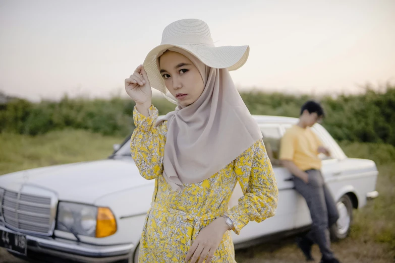 a girl wearing a yellow dress with a white hat