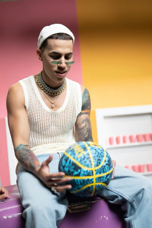 a man sits on a bench, holding a ball