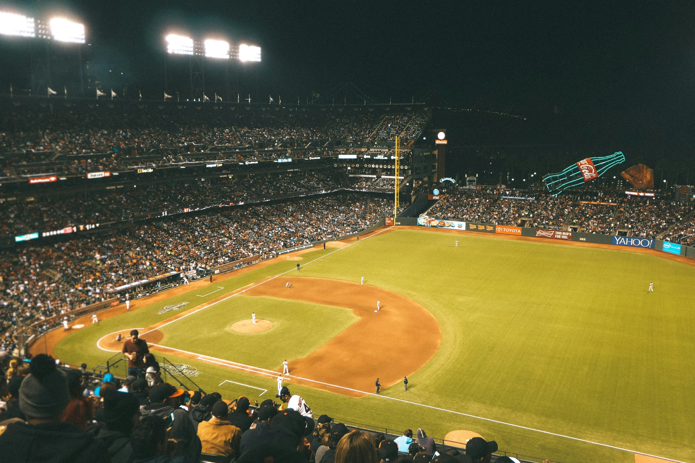 a large crowd of people watch a baseball game in progress