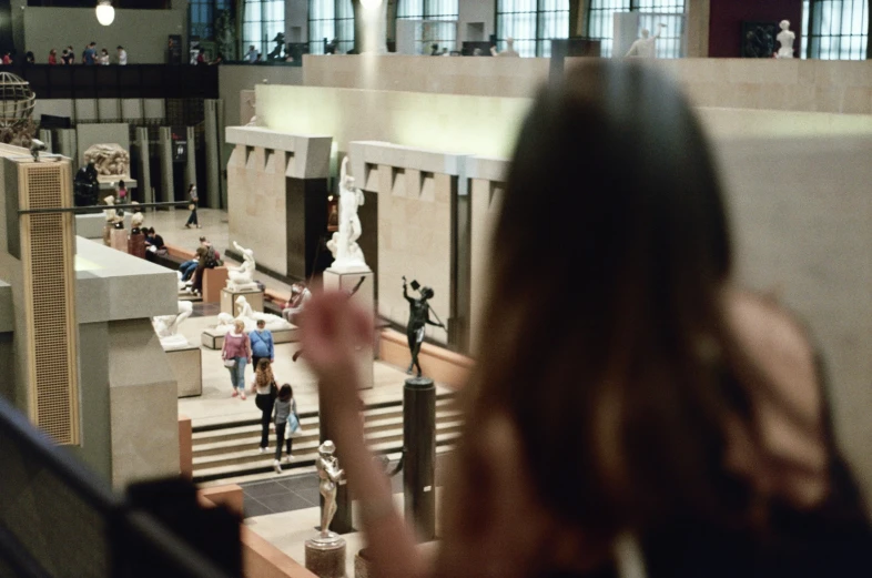 a woman is watching others walk up the stairs