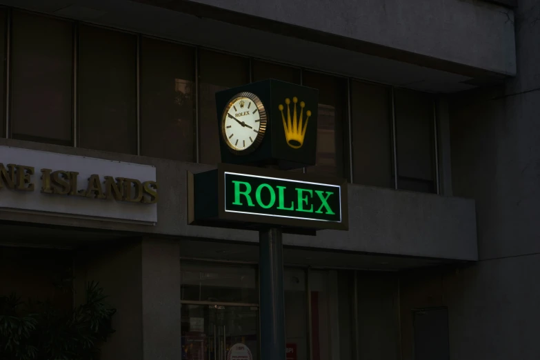 a green rolex sign with the date and name underneath a clock