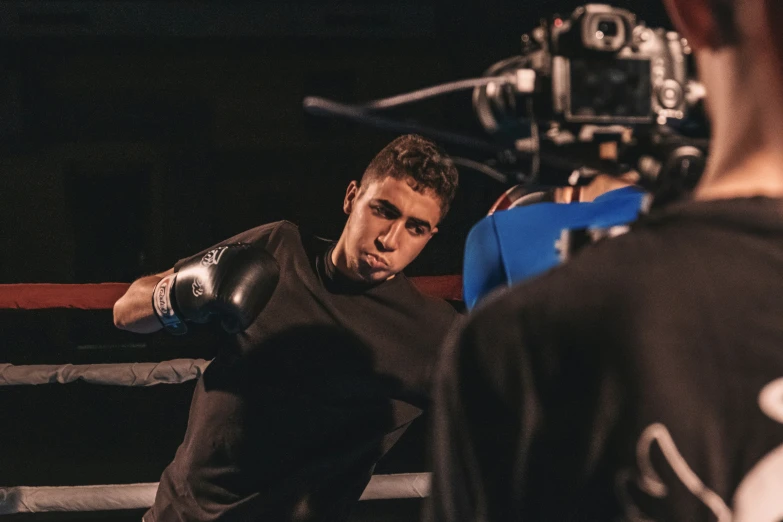 a man boxing wearing black gloves next to a male referee