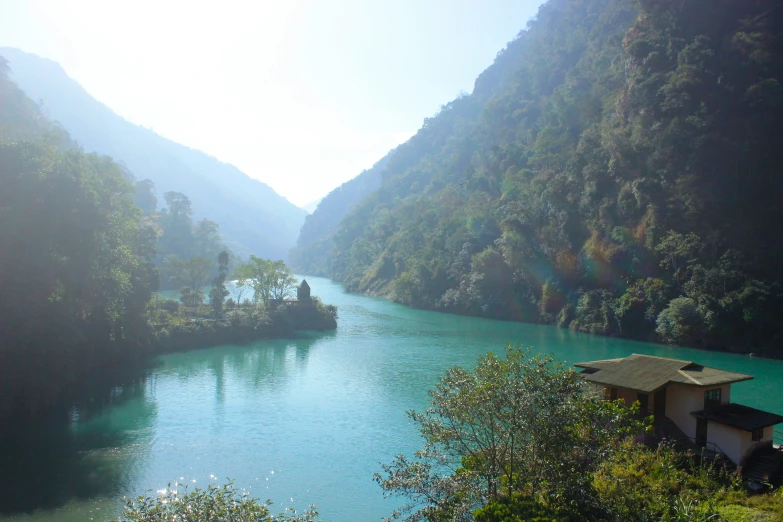 a river running through a green forest covered valley