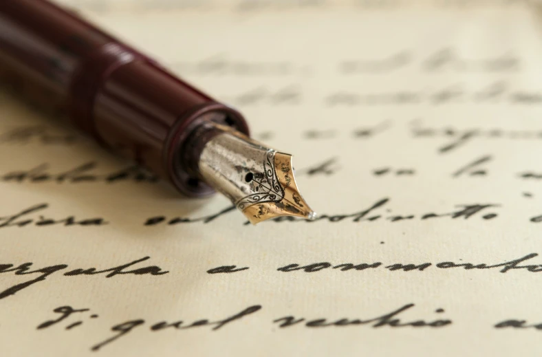 close up of a fountain pen resting on a handwritten letter