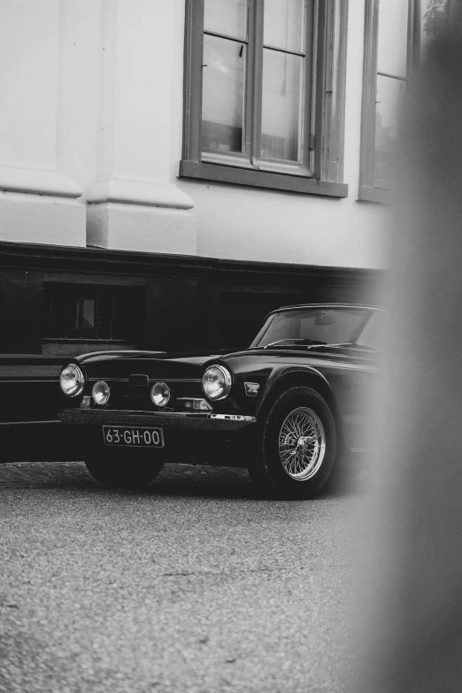 an old car is parked by a building