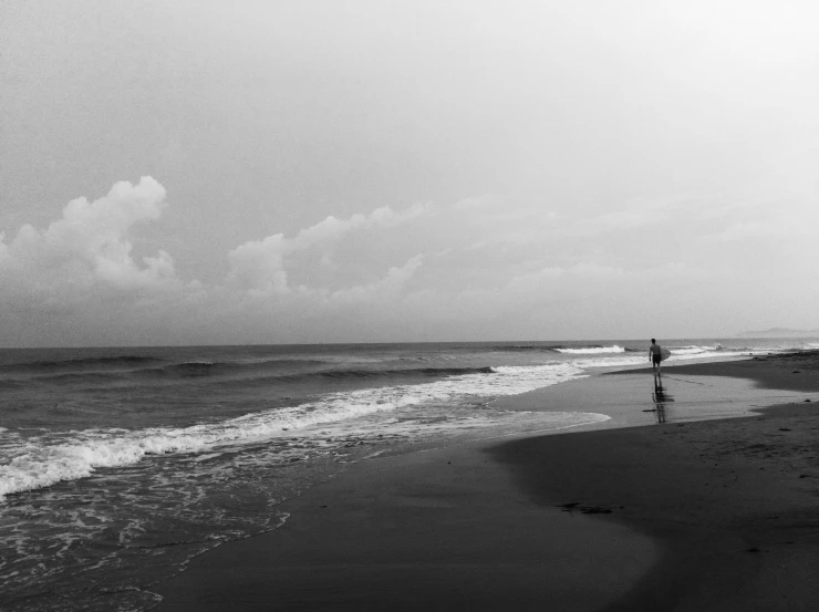 a man is standing on the shore of an ocean