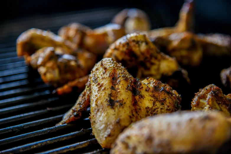 some chicken and potatoes are cooking on a grill