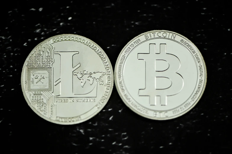 two different designs of two silver coin with one with bitcoin on it