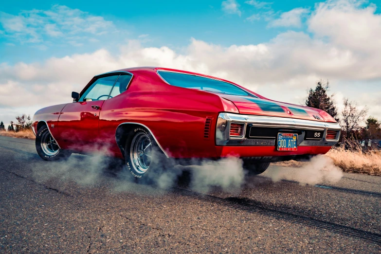 a red classic car blowing smoke on the street