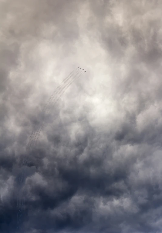 a large kite flying under a big cloudy sky