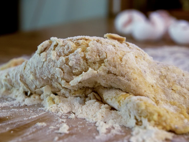 a brown wooden surface topped with a pile of powdered dough