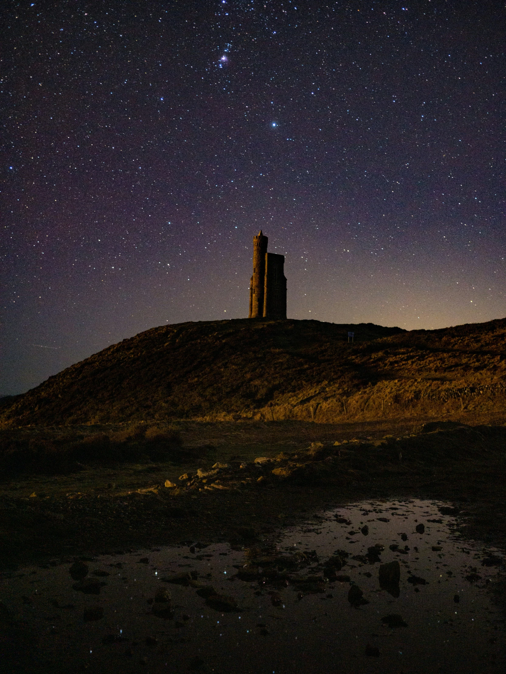 night time view of a field with a hill with a building on it