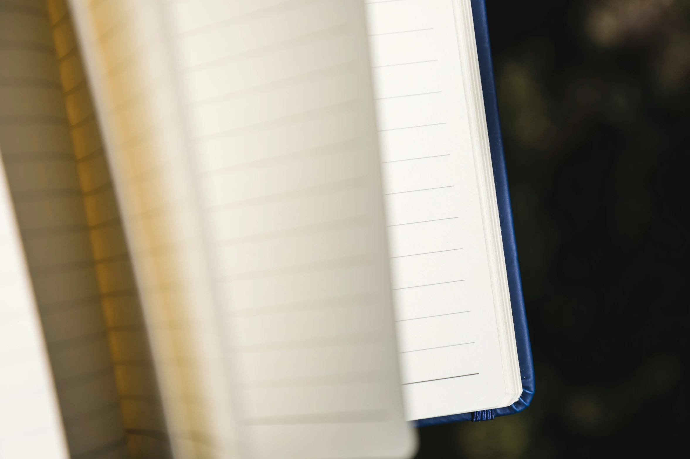 an open notebook and lined notebook on a window sill