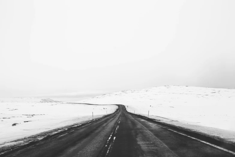 a long road in the middle of snow covered ground