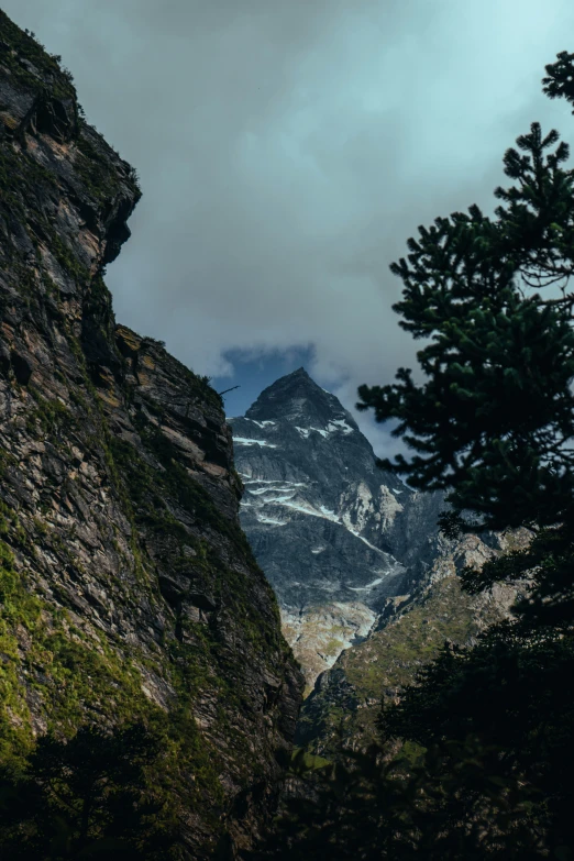 the mountains are tall with rocks and plants around