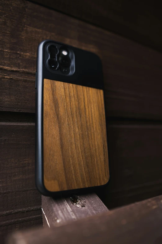 an iphone case made of wood sits on a table