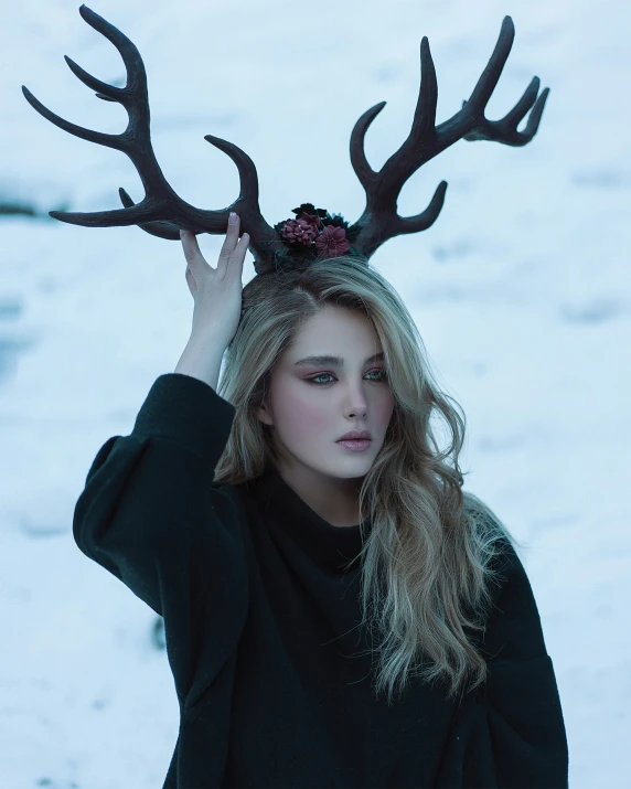 a woman with a large headpiece standing in the snow