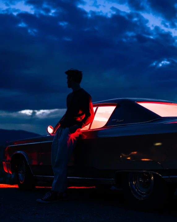 a man standing in the back of an old car