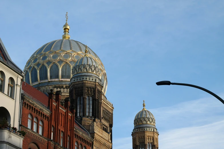 the spires of a church on a building behind a street lamp