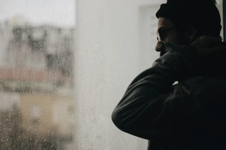 a man talks on his cell phone in the rain outside