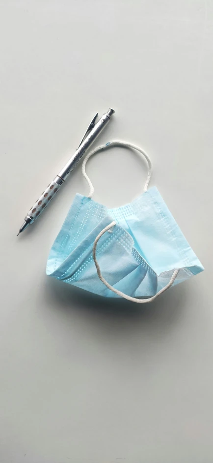 a blue surgical mask sits on top of a dentist's instrument