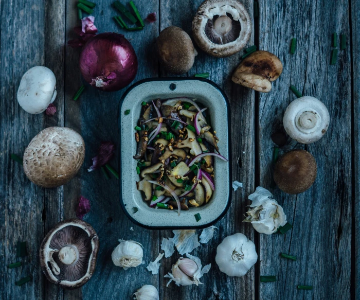 mushrooms, onions and other plants in a plate on a table