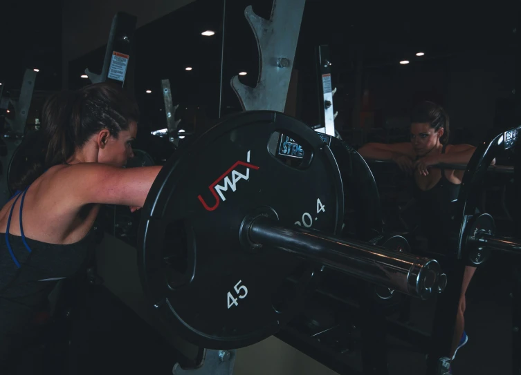 two women in the gym, both are on exercise machines