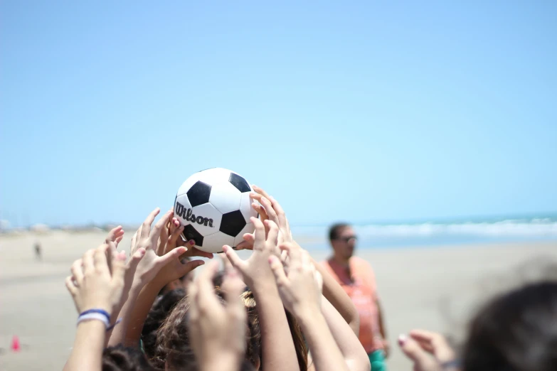 people holding and touching up the back of a soccer ball