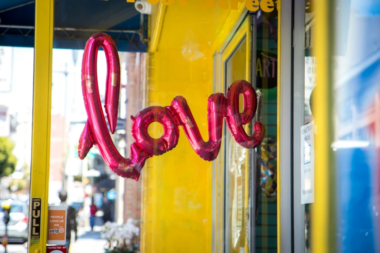 the sign is made with pink inflatable balloon letters