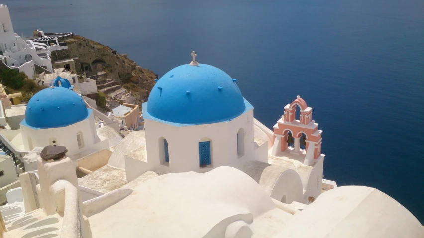 an aerial view of a church next to the ocean